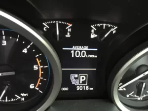 A Vehicle dash showing the average L/100KM fuel economy. 
